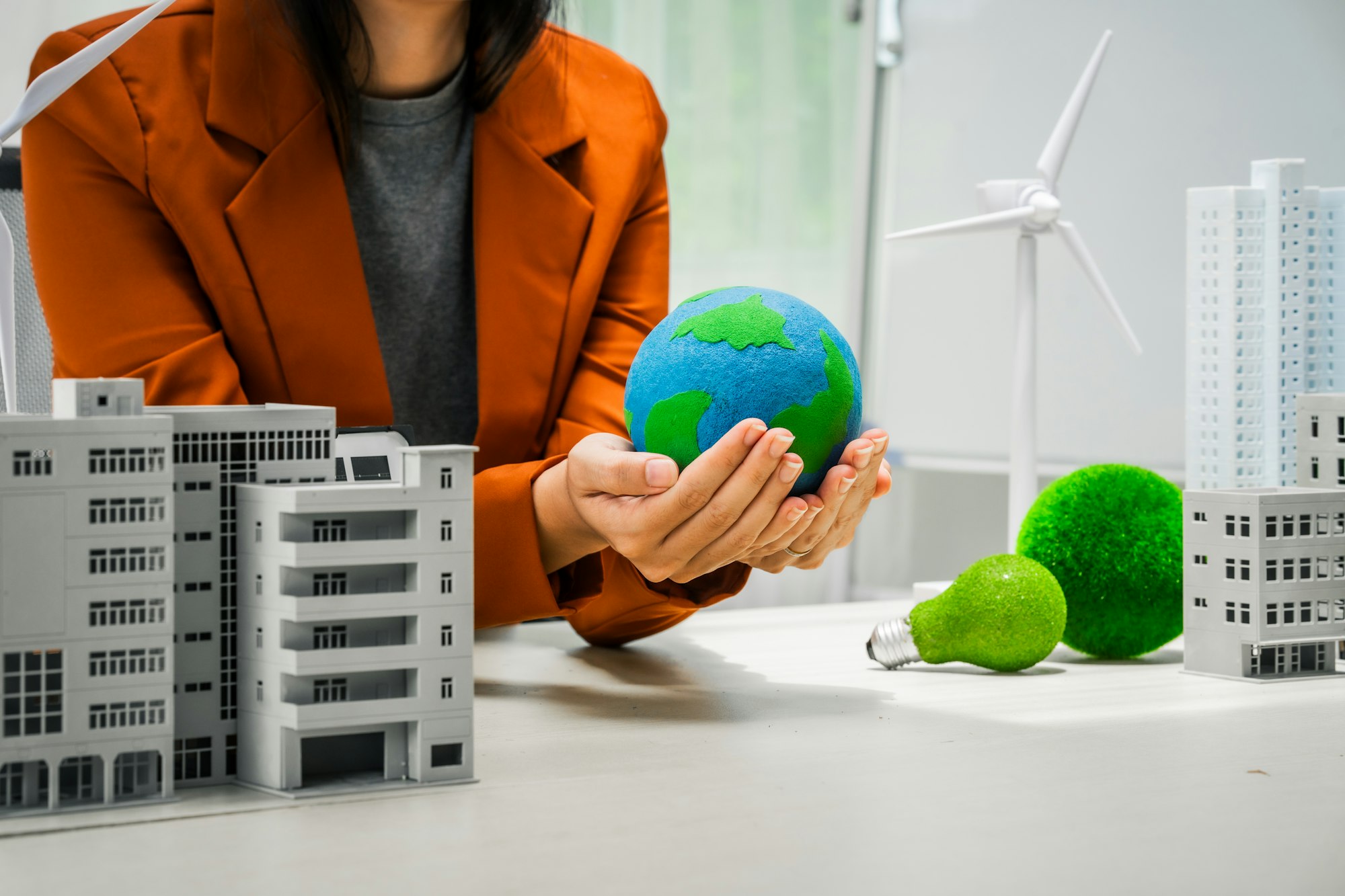 A businesswoman working at a desk in sustainable urban development, promoting eco-friendly